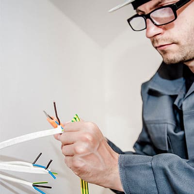 An electrician stripping the cores of new cable during a rewire